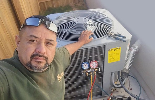 Experienced HVAC technician inspecting an AC unit in Lubbock, TX.
